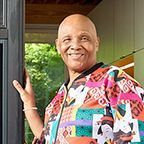 Wallace smiling while standing in the doorway to his new home