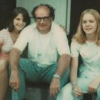 1970s photograph of a family sitting on front steps of a house together
