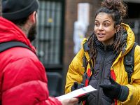 Woman talking with a man, both wearing heavy winter jackets