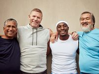Group of four men posing and smiling together