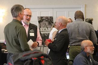 Three men talking together at an event