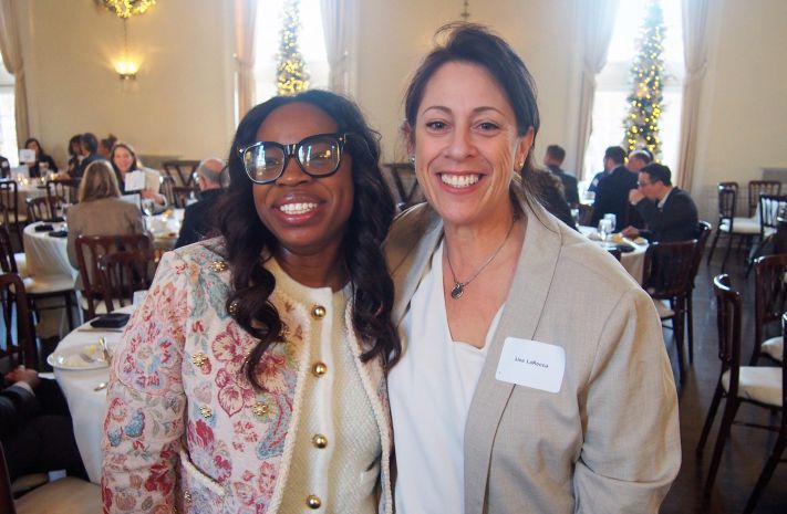 Two women posing together at a banquet event