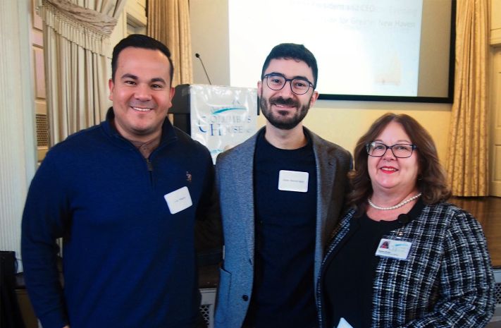 Three people posing together at a Columbus House event