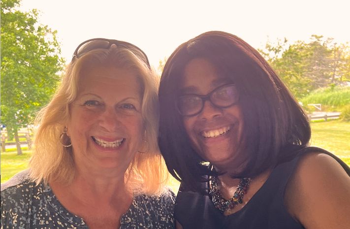Two women posing together outside