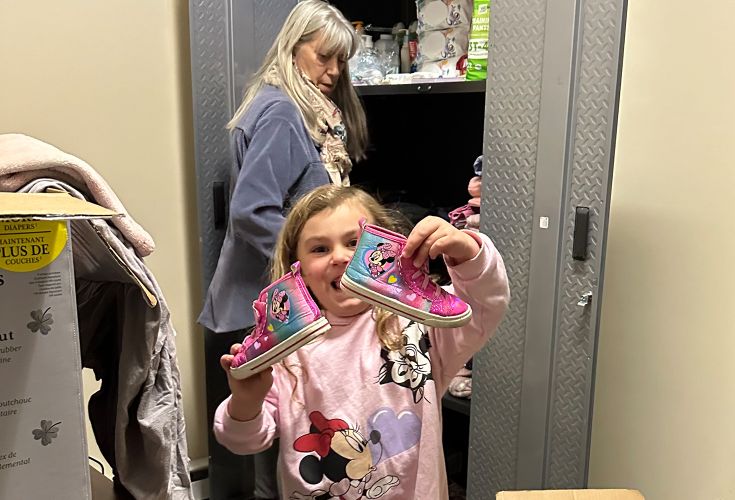 Little girl showing off a pair of sparkly, colorful sneakers