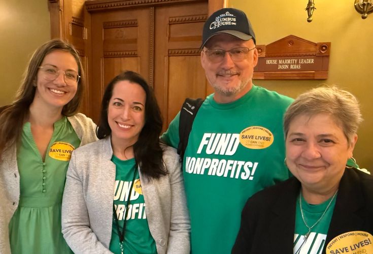 Group of people posing together with green t-shirts that say "Fund Nonprofits!"