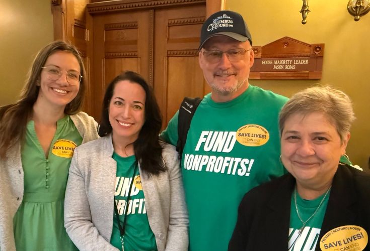 Four people posing together wit t-shirts that say "Fund nonprofits!"