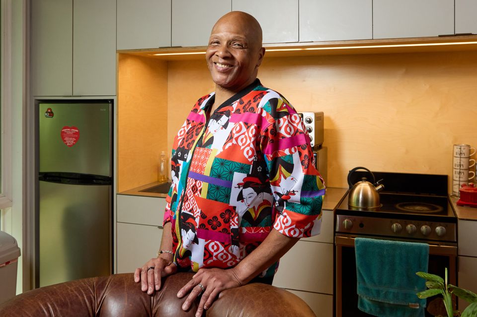 Man posing and smiling inside of an apartment