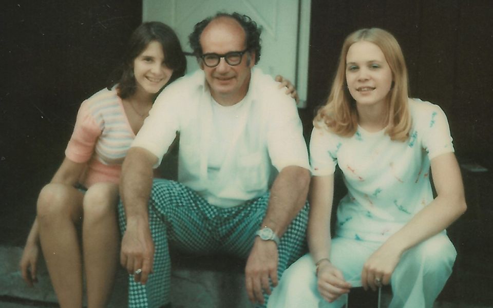 1970s photograph of a family sitting on front steps of a house together
