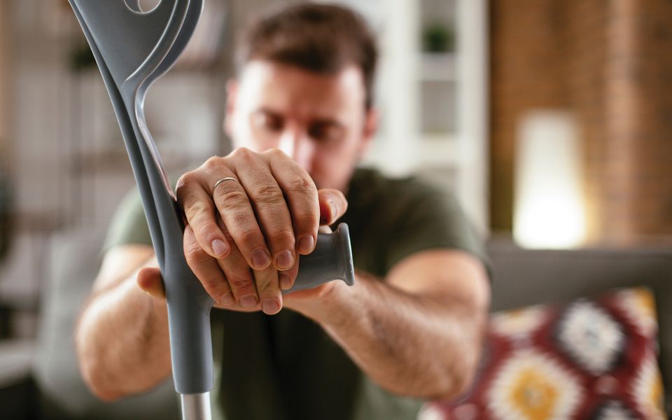 Man holding onto a handle to support himself while closing his eyes.